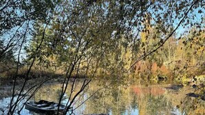 A calm river with a small boat and a dock. - Peaceful Escapes and Retreats (Battle Ground)