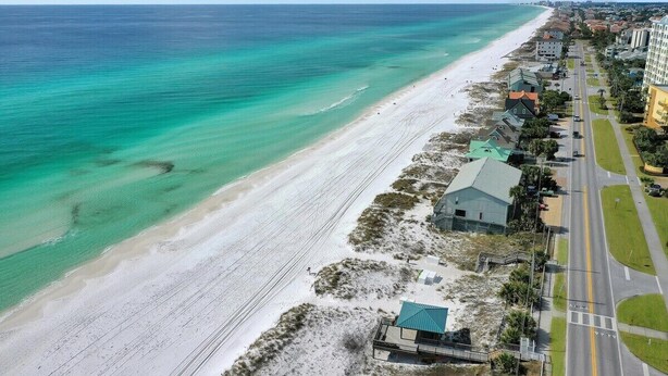 Eine Küstenstraße mit Strand auf der einen Seite und Gebäuden auf der anderen.