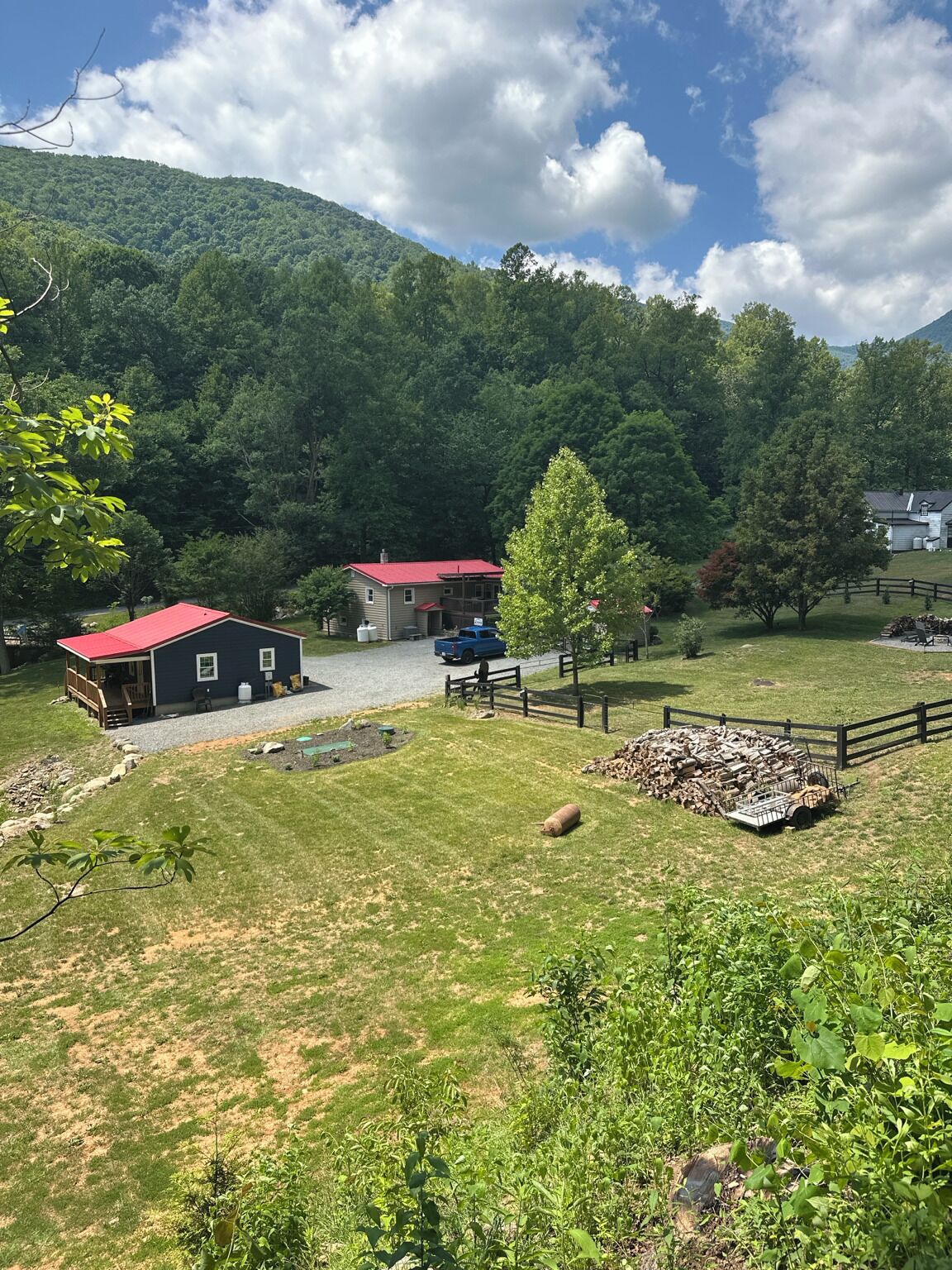 A rural property with a house, a barn, and a fenced yard.