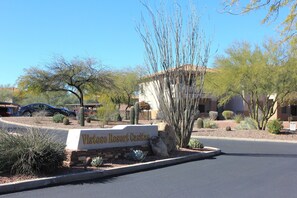A sign for Vista Resort Casitas with a desert landscape and cacti in the background. - Cozy ground level resort style condo with heated pool/hot tub, and gym! (Oro Valley)