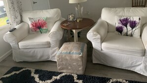 A living room with two white sofas, a small round table with a lamp, and a patterned rug. - Remote Worker? Retired? Storm Tracker? +Own Canal Dock (Ocean Shores)