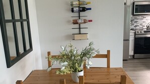 A dining area with a wooden table and chairs, a potted plant, and a wine rack on the wall. - Remote Worker? Retired? Storm Tracker? +Own Canal Dock (Ocean Shores)