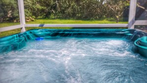 Ein Whirlpool mit Blick auf eine grüne Wiese und Bäume.