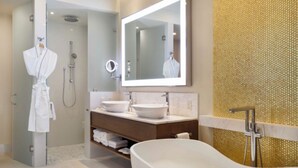 Une salle de bain moderne avec une baignoire sur pieds, un grand miroir et une douche à l’italienne.