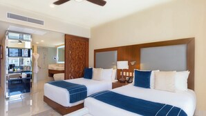Une chambre d’hôtel avec deux lits, une coiffeuse et une kitchenette.