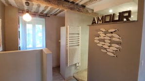 Un couloir avec un radiateur, un mur décoré d’un motif de poisson, et le mot « AMOUR » écrit au-dessus.