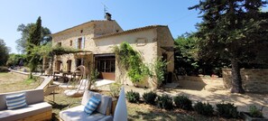 A stone house with a patio, outdoor seating, and a garden. - A typical Provençal farmhouse with 220 m², all the amenities, a pool, and peace and quiet! (Le Thor)