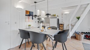 A modern kitchen with white cabinets, a striped tablecloth, and black chairs. - Beautiful home in Hemmet with WiFi (Hemmet)