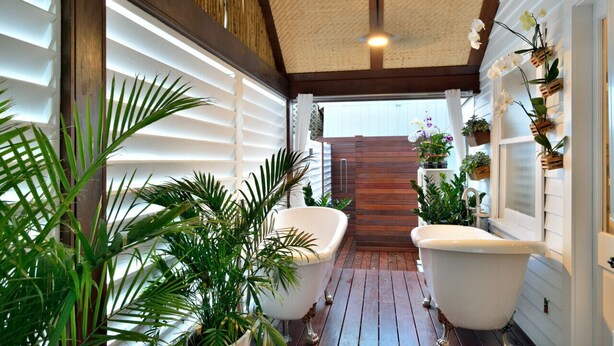 A bathroom with two white clawfoot tubs, wooden flooring, and a ceiling fan. - Old Town Caribbean Estate Key West -  Great for Groups - Private Pool - Sleeps 21 (Key West)