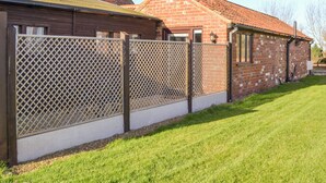 A fenced property with a brick building and a wooden structure. - 1 bedroom accommodation in Mablethorpe (Mablethorpe)