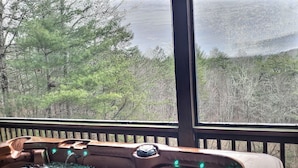 Ein Whirlpool mit Blick auf einen Wald durch ein Fenster.