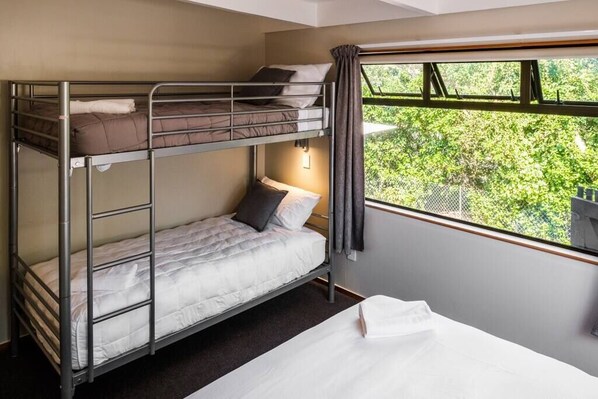 Dormitorio con literas y ventana que ofrece vistas a la vegetación exterior.