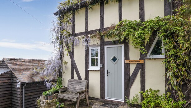 A traditional half-timbered building with a sign reading "Willow Cottage."