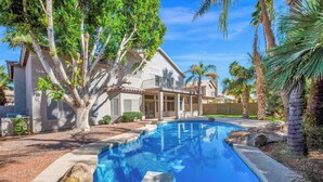 A swimming pool with a house in the background.