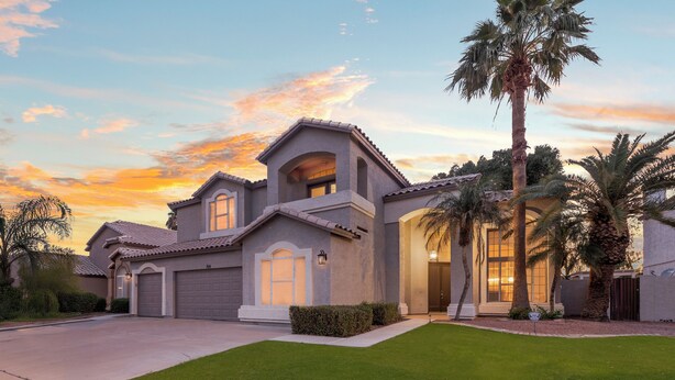 A residential house with a well-maintained lawn, a garage, and a large window.