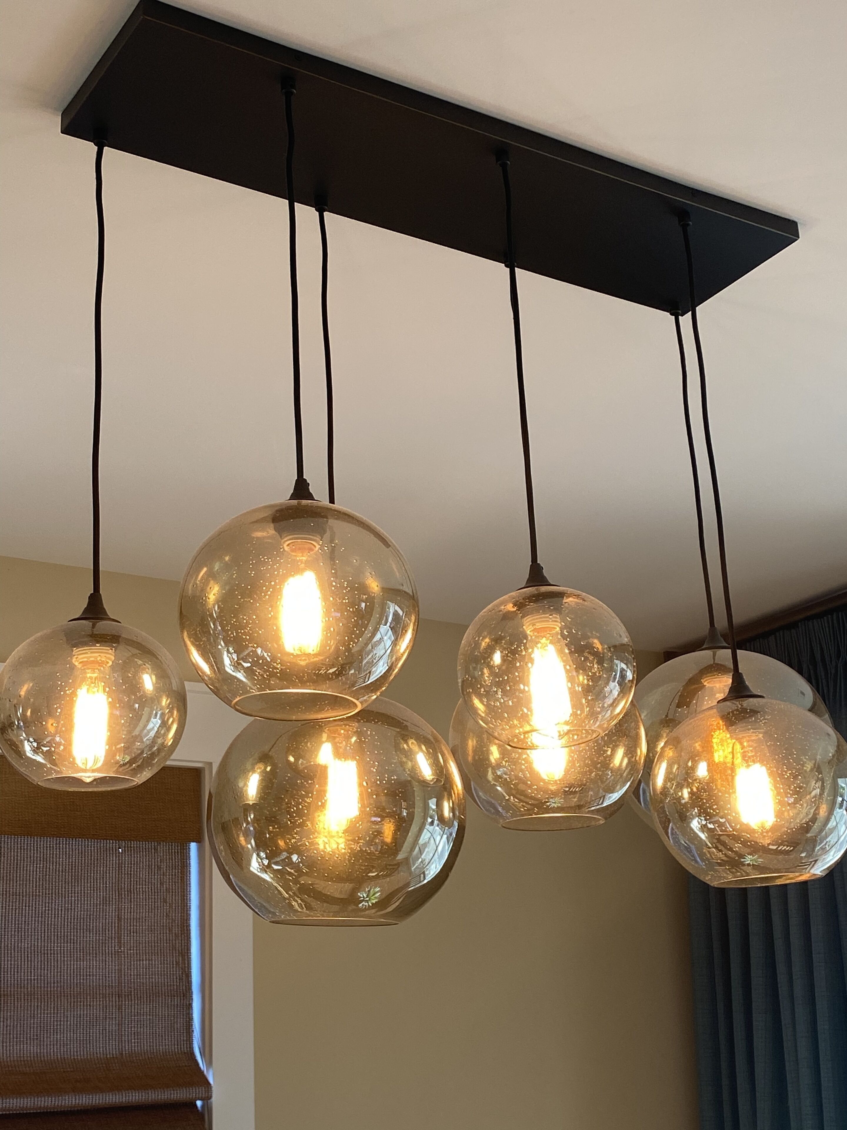 A ceiling-mounted light fixture with four spherical glass globes, each containing a bulb.