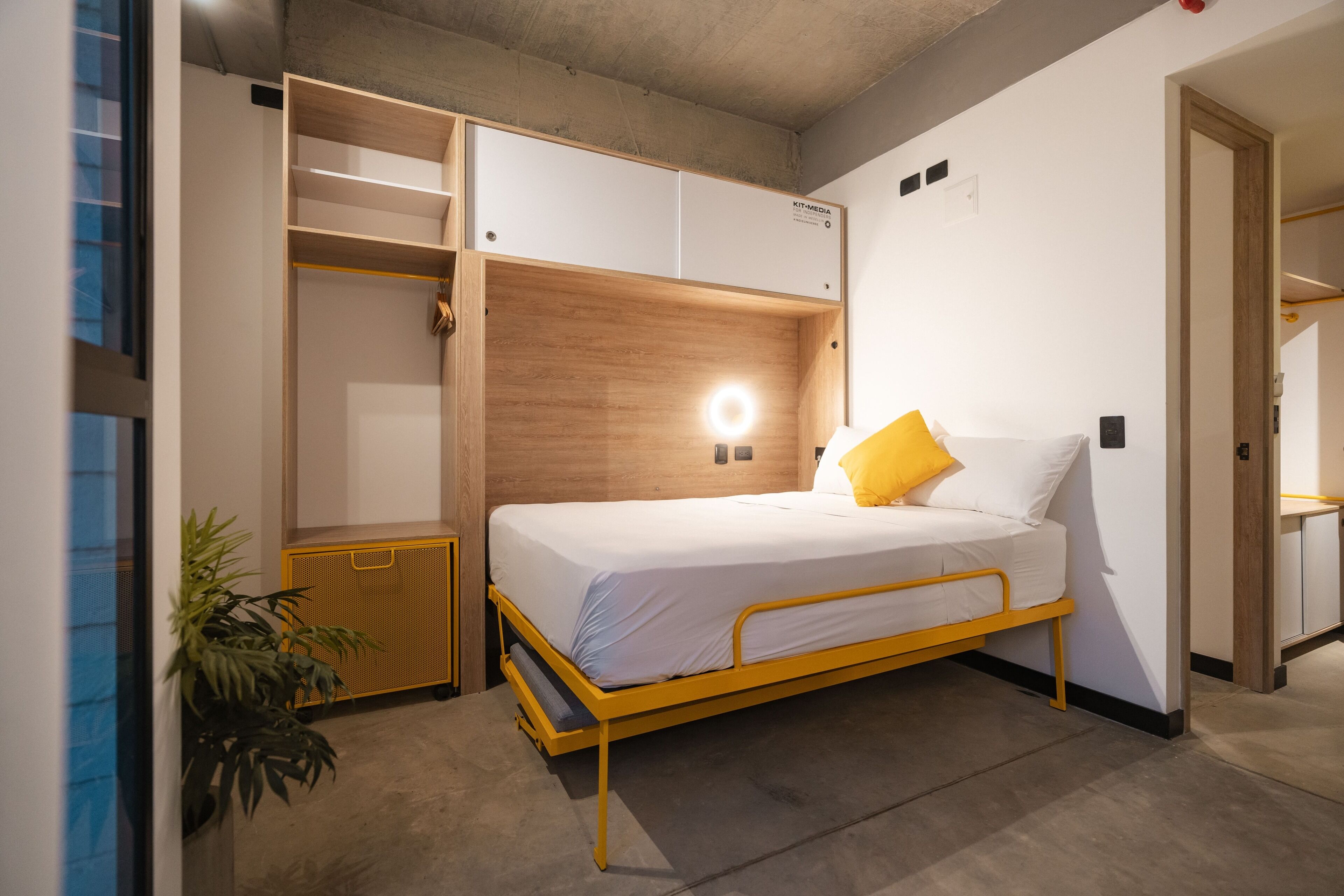 Una habitación pequeña y acogedora con cama, mesita de noche y armario empotrado.