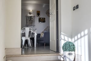 A doorway leading to a dining area with a table and chairs, a sofa, and a decorative plant. - N213 - Numana, new apartment in the center (Numana)