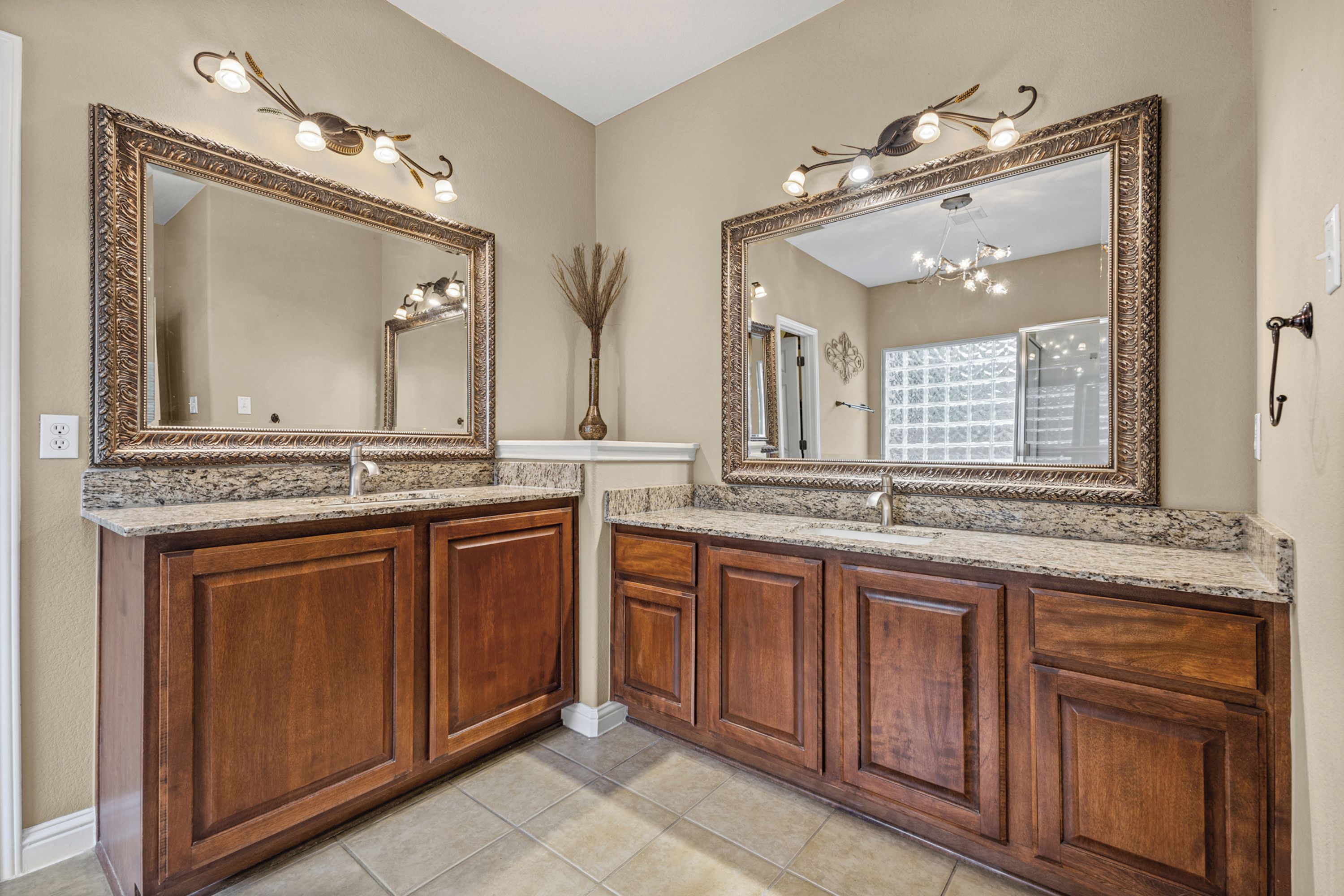Une salle de bain avec deux grands miroirs, un meuble-lavabo et des armoires en bois.