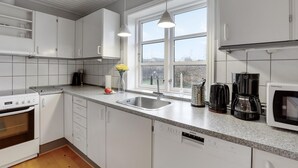 A modern kitchen with white cabinets, a stainless steel sink, a Bosch oven, a Siemens dishwasher, and a window with a view of the outdoors. - Lovely home in Aakirkeby with WiFi (Aakirkeby)