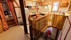 A kitchen with wooden beams, a microwave, and a coffee maker. - The Doves' nest House in the rempart (Riquewihr)