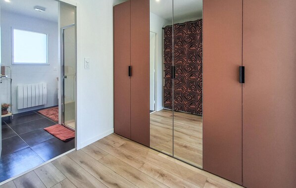 A room with a sliding wardrobe, a glass door leading to a bathroom, and a radiator on the wall. - Beach front home in Ploudalmézeau with WiFi (Ploudalmézeau)