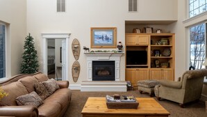 A living room with a fireplace, a Christmas tree, a sofa, a chair, and a coffee table. - Family Getaway~hot Tub, Ice Castles & Tubing Hs 5 Bedroom Home by RedAwning (Midway)