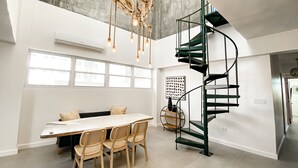 Una cocina moderna con comedor, una escalera espiral y ventanas amplias.