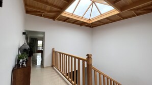 A spacious interior with a wooden staircase, a skylight, and a view into another room. - Luxery spacious 5 bedroom villa, private pool, jacuzzi, pooltable, aircon. bbq

 (Playa Blanca)