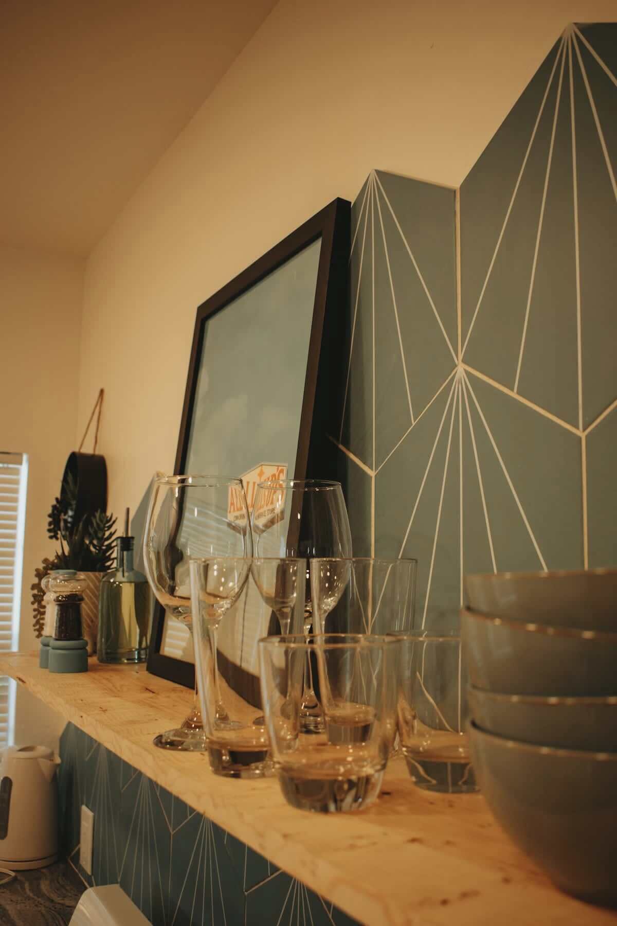 Een keukentafel met verschillende glazen en een ingelijst foto.