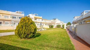 A residential area with houses, a well-maintained lawn, and a paved walkway. - 2 bedroom amazing home in Orihuela (Orihuela)
