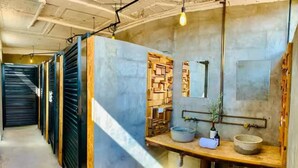 A narrow hallway with a wooden counter on the right, a mirror, and a hanging light fixture.