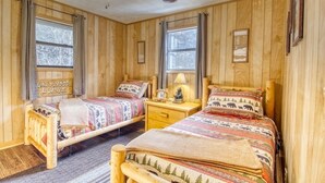 A cozy cabin-style bedroom with two wooden beds, a ceiling fan, and a window with a view of trees. - Private - Spacious- Creek Lined Cabin  (Cosby)