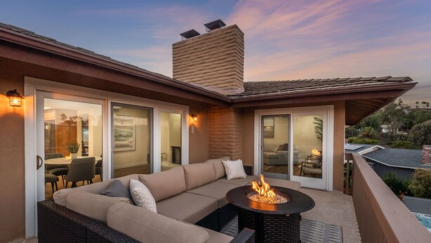 A modern outdoor living area with a fire pit, a large sectional sofa, and a dining table. - Amazing Escape with Game Room, Pool & Hot Tub (Escondido)