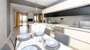 A modern kitchen with a dining area. - Maison Elisa a Manerba By Bookinggardalake (Manerba del Garda)