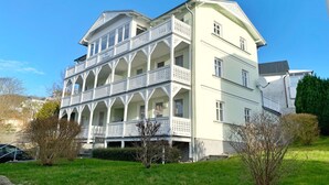 Un immeuble à plusieurs étages, doté d’une façade blanche et de balcons.