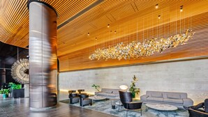 A modern lobby with a high ceiling, a large column, and a seating area with sofas and tables. - Pars Apartments Melbourne Quarter (Docklands)