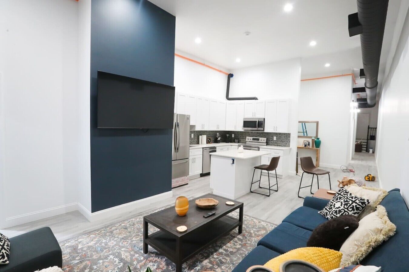 A modern apartment with a living room, kitchen, and dining area.