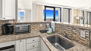Una cocina con un tostador, cafetera y un lavabo.