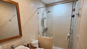 A modern bathroom with a large sink, toilet, and glass shower enclosure. - Nelayan Sanur Bay (Bali)