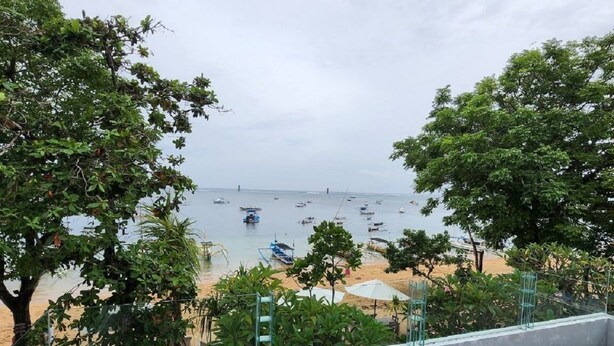 A balcony with a view of a beach and boats. - Nelayan Sanur Bay (Bali)