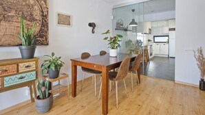 A modern dining area with a wooden table, chairs, and potted plants.
