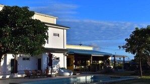 A two-story house with a swimming pool, outdoor seating, and a covered patio area. - Kenting Grandmas (Hengchun)