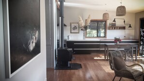 Una cucina moderna con una grande isola, pavimento in legno ed estetica rustica.