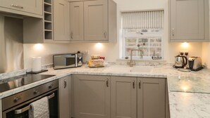 A kitchen with a microwave, toaster, and sink. - 9 Station Cottages (Belford)