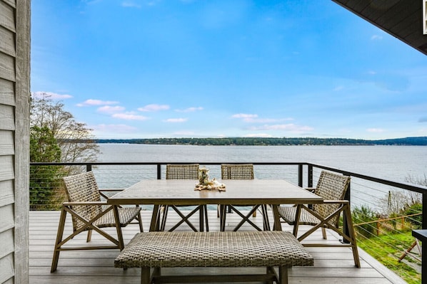 Une terrasse avec une table et des chaises donnant sur un lac.