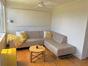 Relax in this inviting living space with a comfortable sofa, a small table, and a ceiling fan.