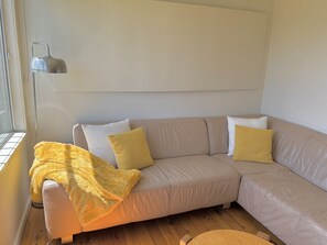 Relax in this inviting living room with a comfortable sofa, throw pillows, and a cozy throw blanket.