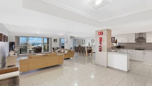 A modern apartment with a living room, dining area, kitchen, and a balcony with a city view.