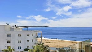 Un hôtel situé sur la côte, avec vue sur la mer et donnant accès à une plage de sable.